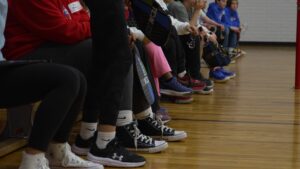 Élèves assis sur un banc dans une salle de gym