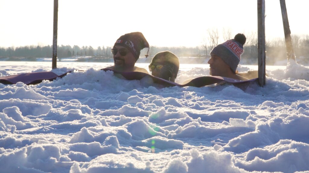 Trois personnes prennent un bain glacé dans le Saint-Laurent gelé