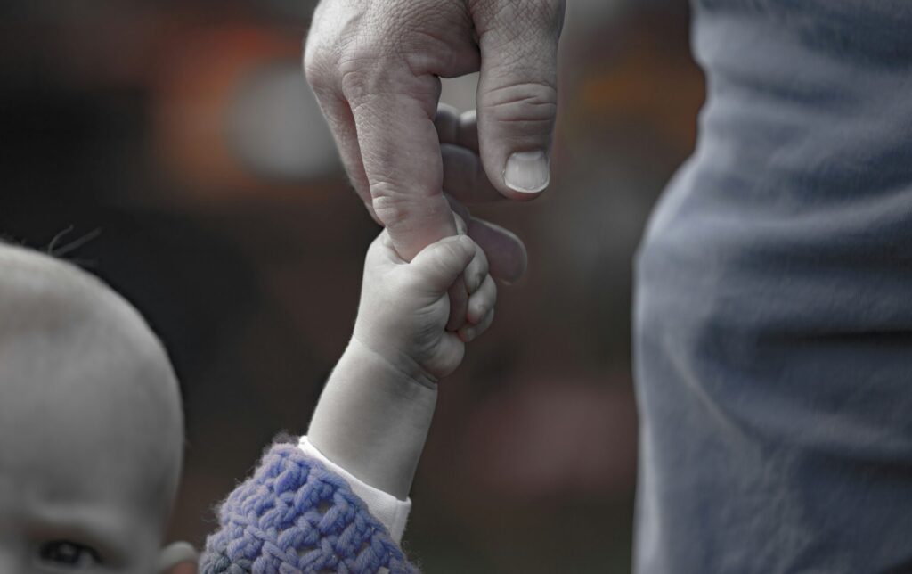 Main d'un enfant qui tient le doigt de son père