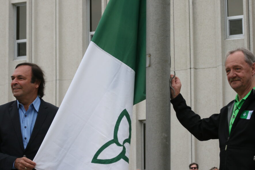Levée du drapeau franco-ontarien en 2015, à l’occasion de son 40e anniversaire. Deux artisans du drapeau : Donald O’Bonsawin (à gauche) et Michel Dupuis.