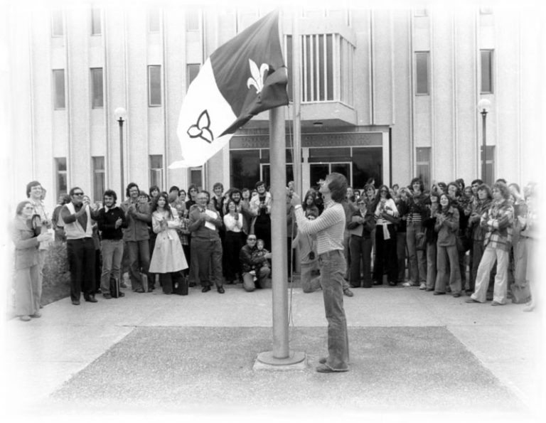 Moment historique en 1975 : Michel Dupuis hisse le nouveau drapeau franco-ontarien à l’Université de Sudbury