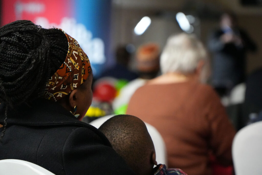 Femme noire avec un enfant sur les genoux vue de dos