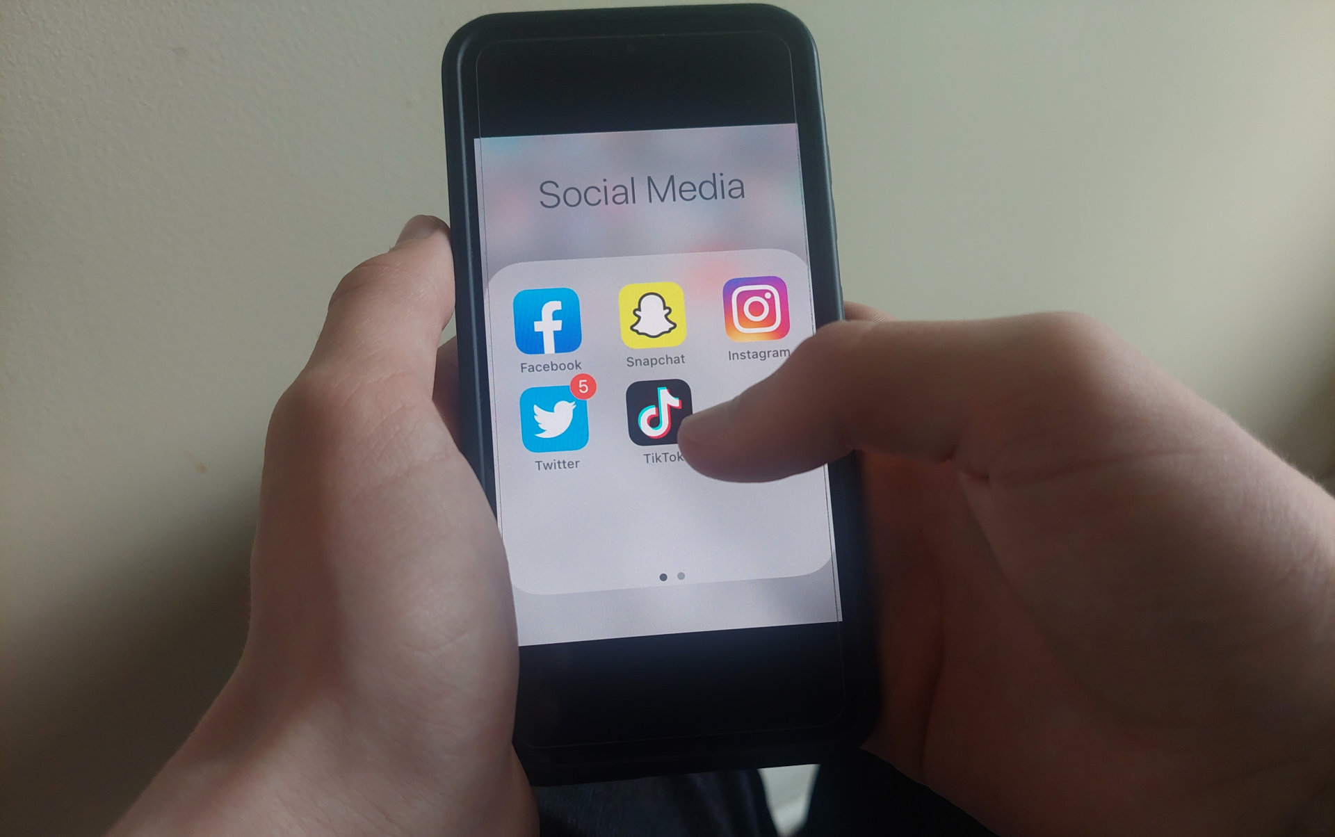 Jeunes qui tient un cellulaire dans les main avec un menu de média sociaux