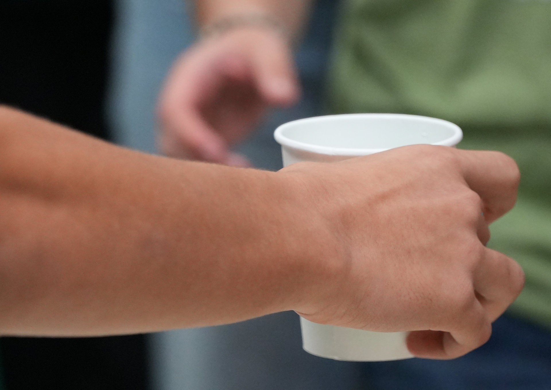 main qui tend un verre vers une autre
